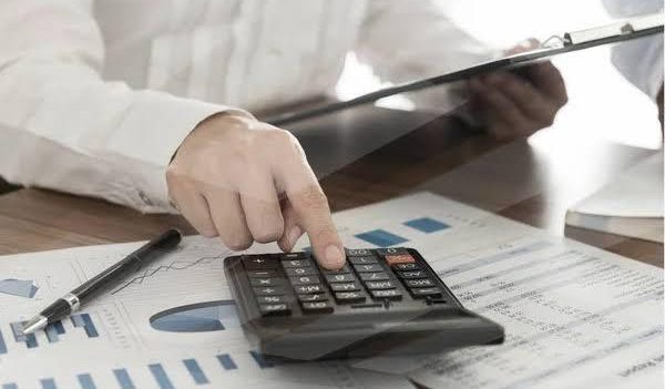 Small business owner using a calculator to avoid common tax mistakes in Downers Grove