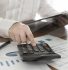 Small business owner using a calculator to avoid common tax mistakes in Downers Grove